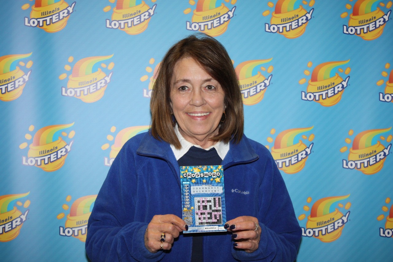 Kathy Ulrich holds her winning Crossword ticket.